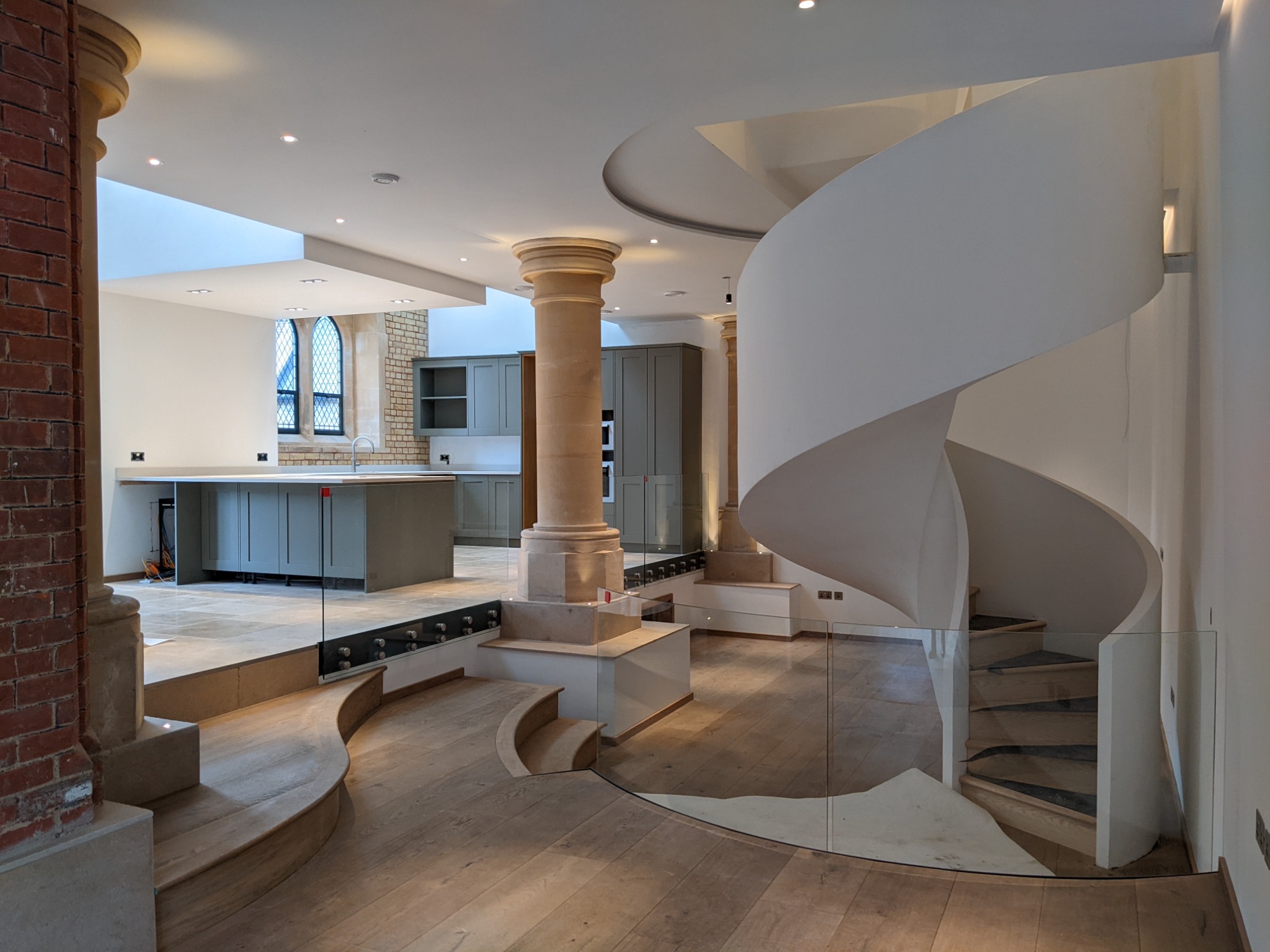Christ Church, Teddington Modern interior featuring a spiral staircase, open kitchen, and stylish architectural elements.
